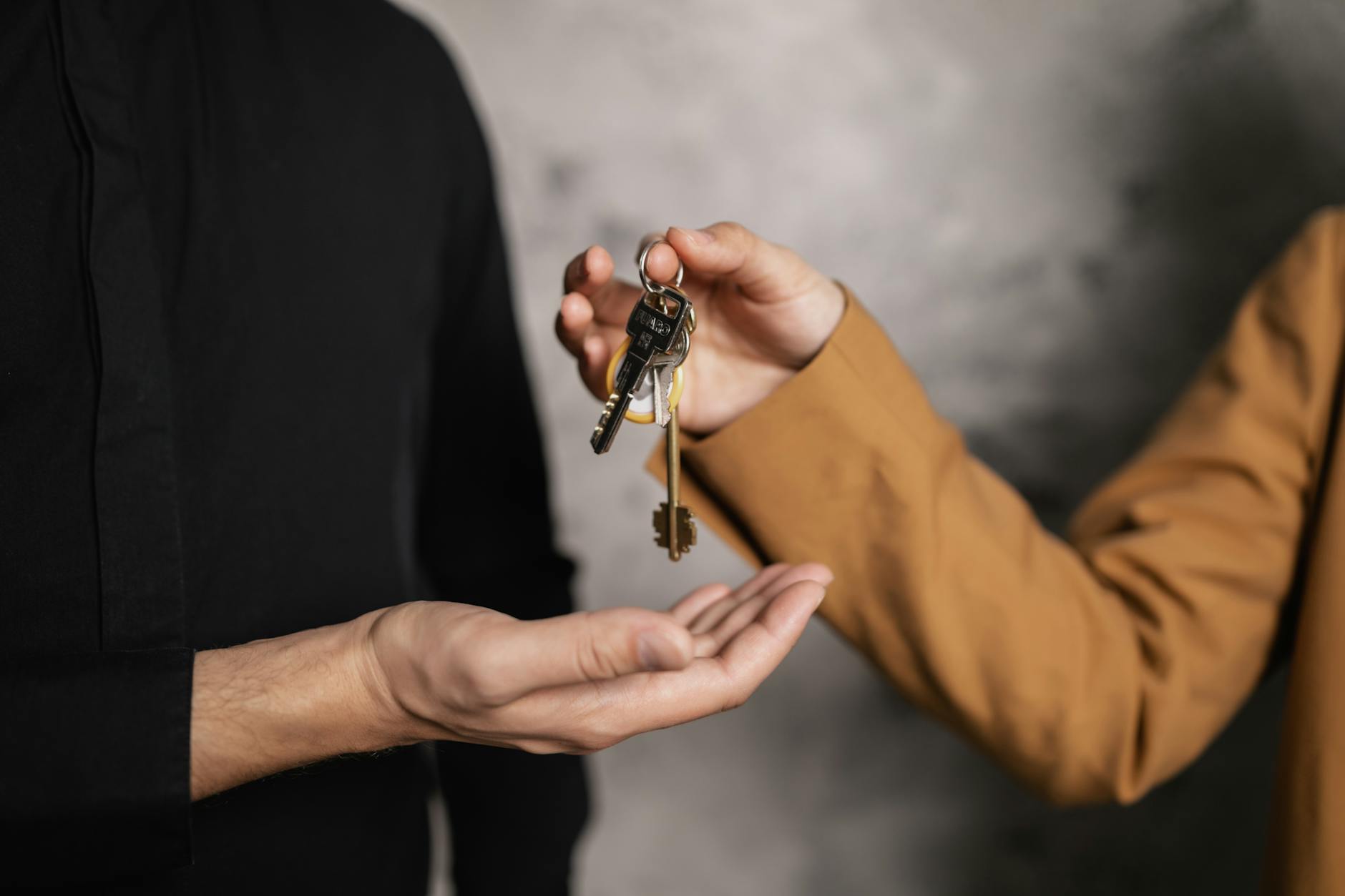 a person giving a bundle of keys to another person